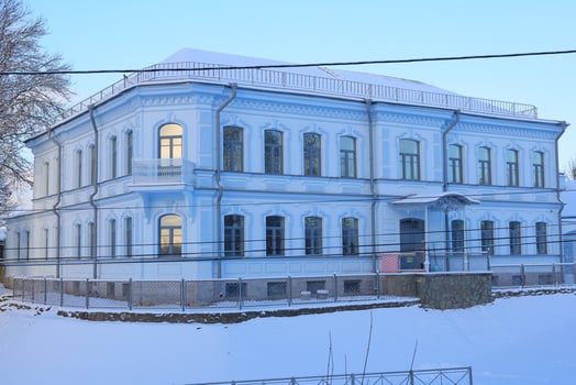A Charming Blue Historic Building beautifully situated within a serene Winter Landscape photo