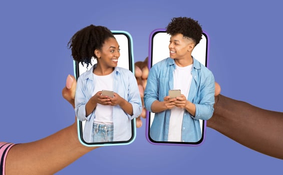 A happy couple shares moments of connection through their smartphones. Their expressions reflect love and affection as they engage in a virtual chat. They are together in a relaxed atmosphere. photo