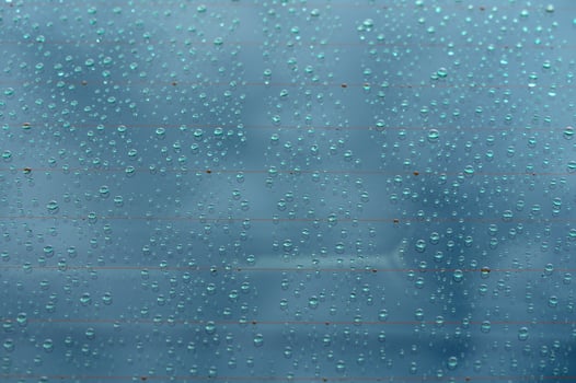 Reflections of a cloudy sky through rain-spattered glass on a tranquil afternoon photo