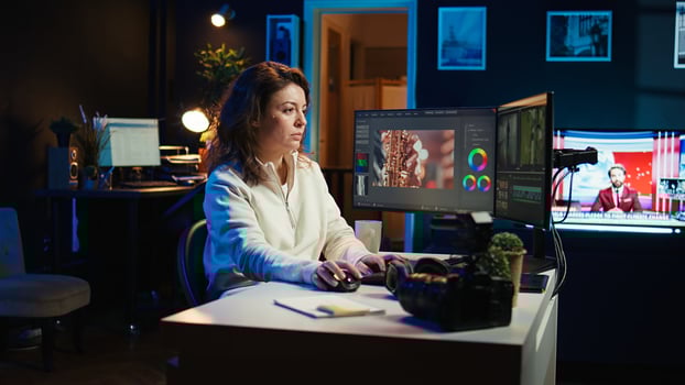 editor selecting key frames to use while doing montage, working from home on computer. Cheerful woman using mouse to edit movie project footage in office, camera B photo