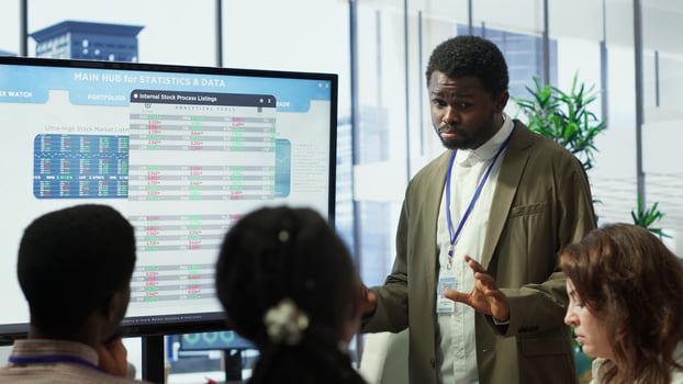 Business professional staff gather to review project development progress, detailed reports and statistics on interactive board to ensure strategic objectives. Diverse work team in meeting. Camera A. photo