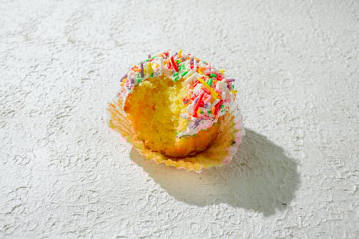 a cupcake with sprinkles on white background photo