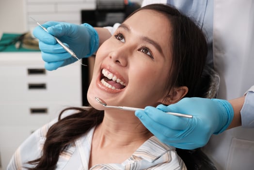 Close-up shot of beautiful female face, white teeth, and cheerful face in dentist's hand, dental treatment with tooth whitening and cleaning in doctor hospital clinic, oral hygiene healthcare. photo