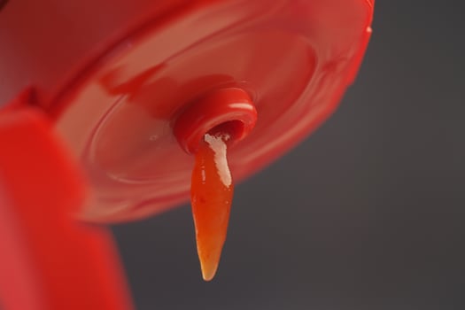 A CloseUp of a Ketchup Bottle that has an Open Lid Ready to Use for Dipping and Adding Flavor photo