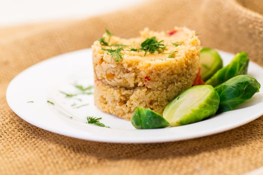 Vegetarian food. homemade cooked bulgur with Brussel sprouts in a plate, on a wooden table photo