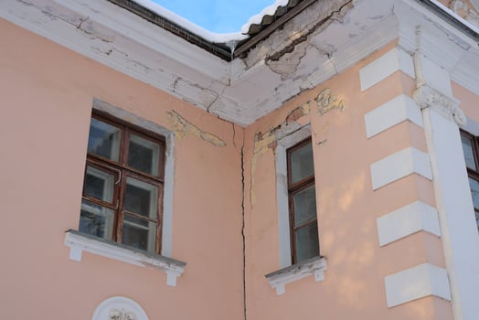 Architectural Details Highlighting the Cracks on a Corner of a Historical Building photo