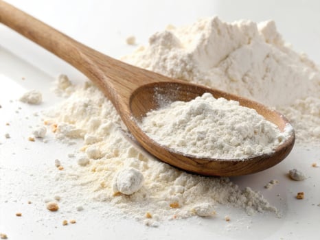 Fresh white flour in wooden spoon, perfect for baking and cooking photo