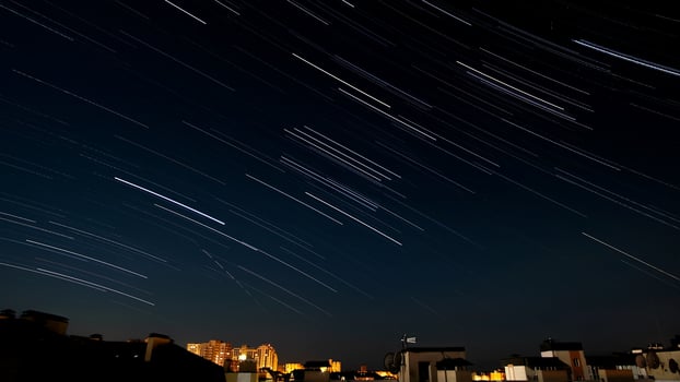 Star trails in the night sky over the city. photo