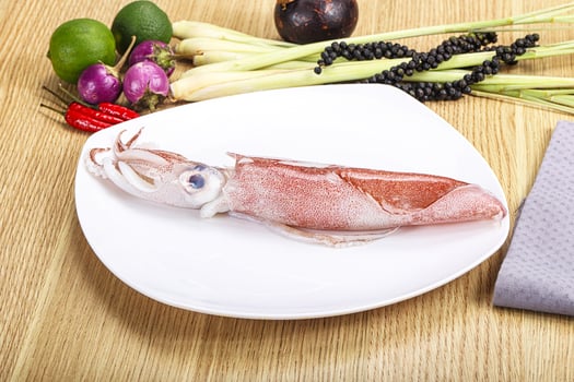 A squid on a plate with other vegetables and a napkin photo