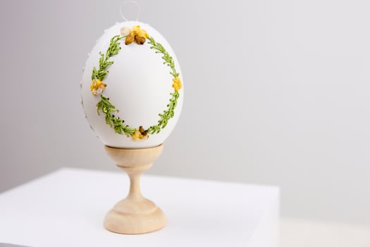 White Easter eggs made with decoupage technique with floral motifs and a flowering branch on a black rustic background. photo