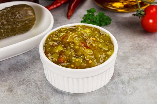 A bowl of pickles and a jar of pickles photo