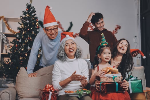 family exchanging presents during christmas at home. Attractive happy people holding gift box, celebrate holiday thanksgiving, xmas eve tradition in living room in house together. photo