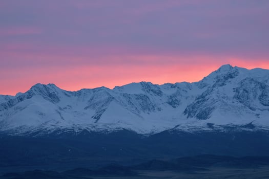 Soft pink light glides over the snow-capped peaks of the mountains in the early morning. Beautiful mountain landscape of the North Chui ridge, with snow-capped mountain peaks, beautiful pink glow. photo