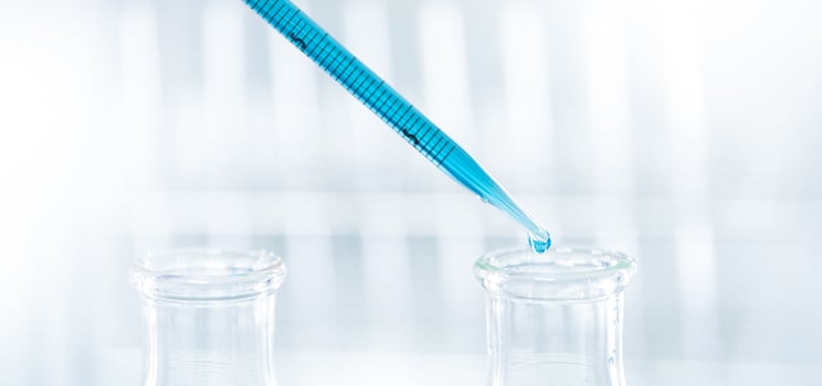 Doctor or scientist using pipette to drop a sample to test tube in medical research lab photo