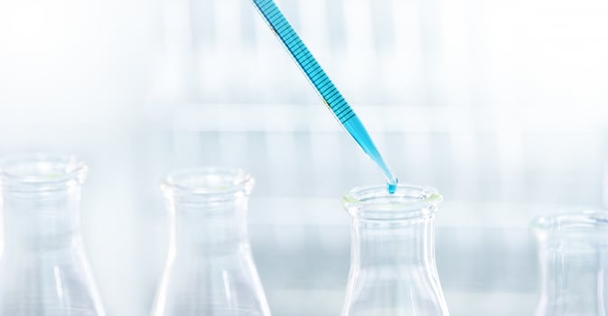 Doctor or scientist using pipette to drop a sample to test tube in medical research photo