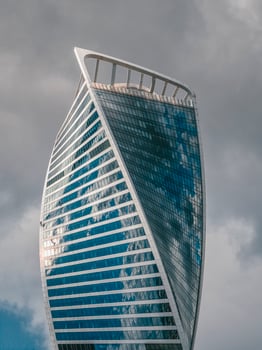 Modern high-rise building made of glass and concrete with small silhouettes of high-rise workers on the wall photo