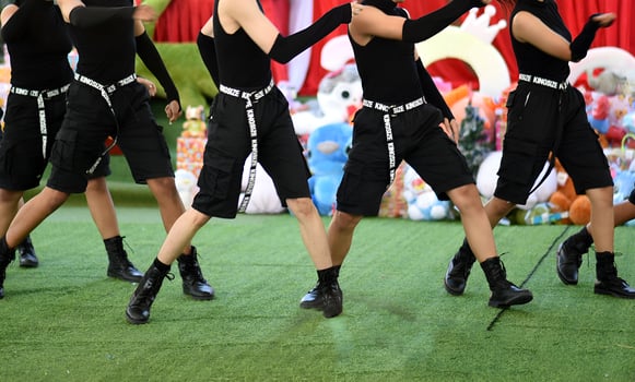 A group of people are dancing on a green field photo