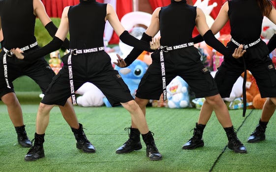 Four people are dancing on a green field photo