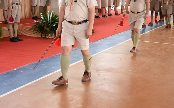 Two men in khaki shorts and brown shoes are walking down a red carpet photo
