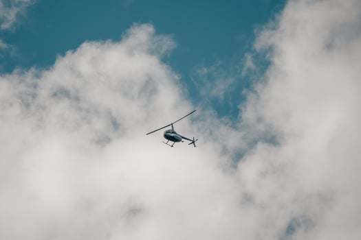 A small helicopter in a cloudy sky. Private flights, transportation of tourists. photo