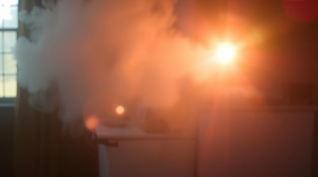 A steam cloud is seen in the dark room photo