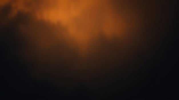 A dark sky with orange clouds and a bright light photo