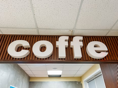 The word coffee is elegantly displayed on a beautifully crafted wooden sign, showcasing the natural grain and character of the wood, accentuated by the rich hues of the wood stain used photo