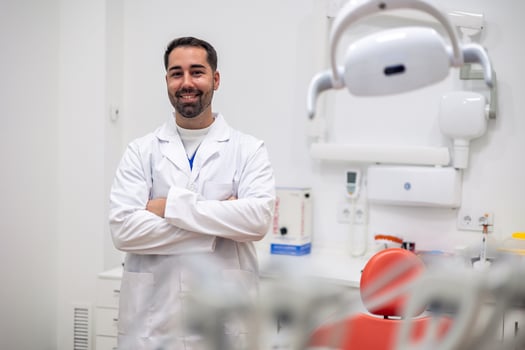 Portrait of dentist smiling with crossed arms in dental clinic photo