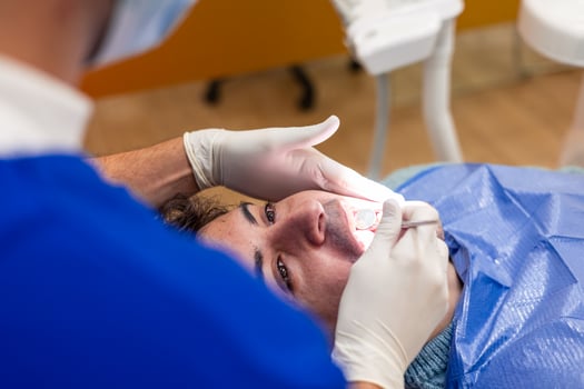 Dentist performing dental checkup on patient's teeth photo