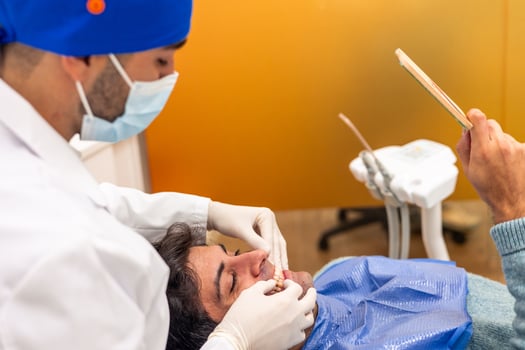 Dentist examining patient's teeth with dental equipment in clinic photo