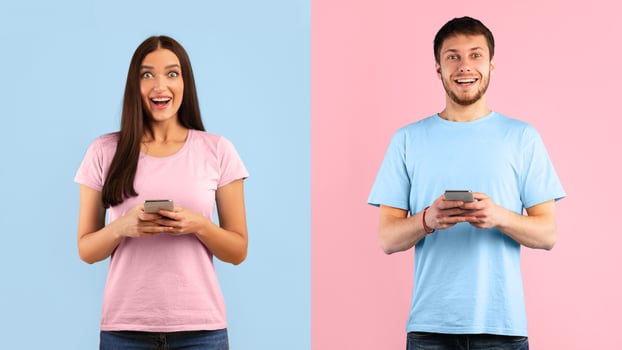 Great News. Surprised positive couple using smartphone devices, chatting online, typing sms, glad to recieve many messages, looking overjoyed at camera, connected to wireless internet photo