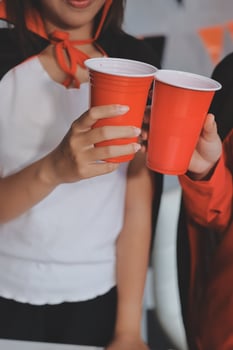 A woman holding a red cup and a man holding a red cup photo