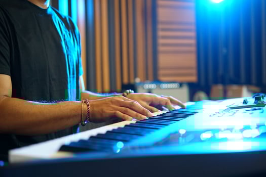 Close up of Musician playing music keyboard, Asian man in black shirt playing piano and practicing in home studio photo