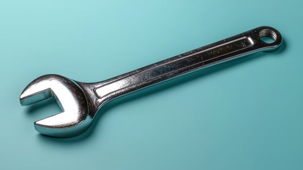 Close up of a silver wrench on a light blue background photo