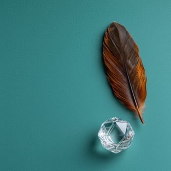 Brown feather and crystal on teal background photo