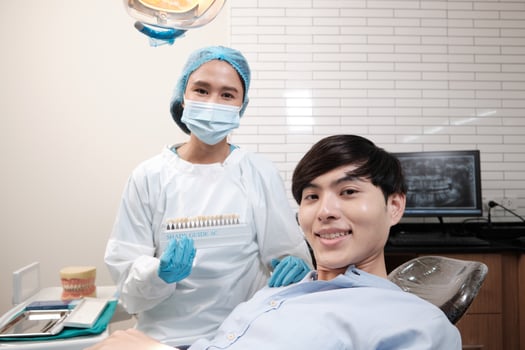 Portrait of Asian female dentist and patient with tooth whitening shades implant, happy smile, and looking at camera in dental clinic, mouth hygiene healthcare work in a doctor's hospital. photo