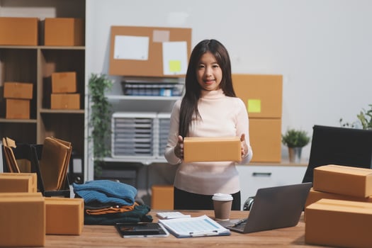 A woman is holding a box in her office photo