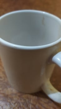 a white coffee cup sitting on a wooden table photo
