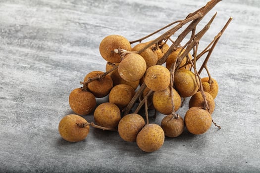 A bunch of longan fruit on a wooden table photo
