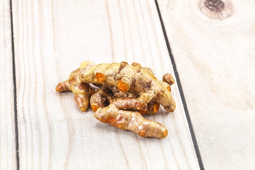 A pile of ginger on a wooden surface photo