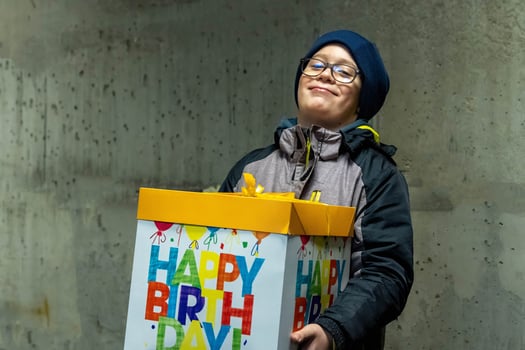 Happy boy holding a big birthday gift box photo
