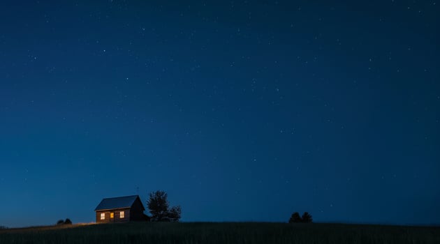 A small house sits on top of a hill at night photo