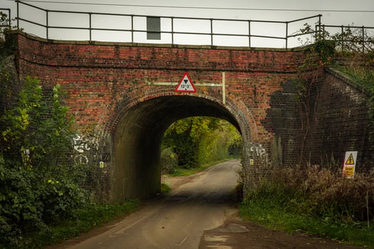 Low brick bridge passing over narrow country road in autumn photo