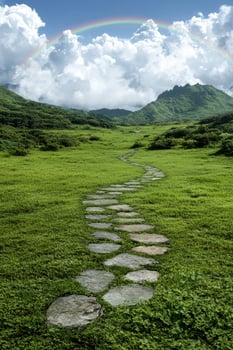 Stone path leading to mountains under a rainbow photo