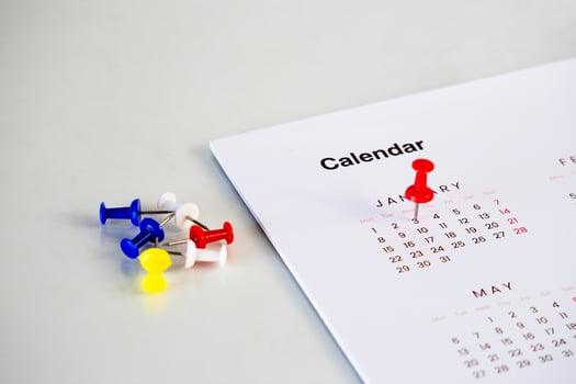red pin stack in calendar on table photo