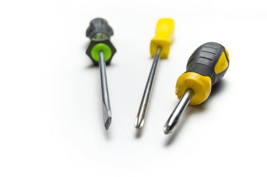 Different old screwdrivers on a white background. Cross, minus and with a rubber handle against electric shock. High quality photo