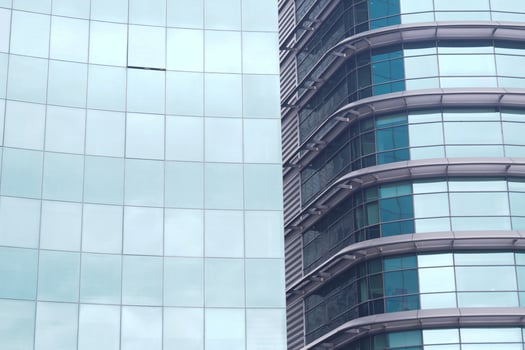 A modern office building facade with large glass windows that reflect its surroundings photo