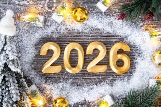 Happy New Year golden numbers 2026 on grey wooden background with Christmas tree, snow, lights of garlands. Greetings, postcard. Calendar, cover photo