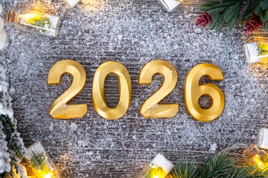 Happy New Year golden numbers 2026 cozy grey wooden background with Christmas tree, snow, lights of garlands. Greetings, postcard. Calendar, cover photo
