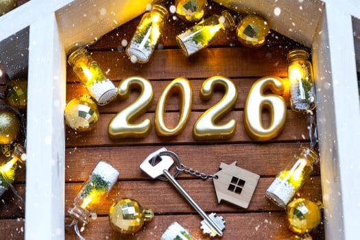 Golden figures number 2026 tiny home on background of cozy windows of a house with warm light with festive decor of stars,snow and garlands. Greeting card, Happy New Year, cozy home photo